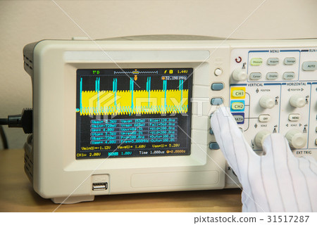 Modern oscilloscope, man's hand adjusting wave 31517287
