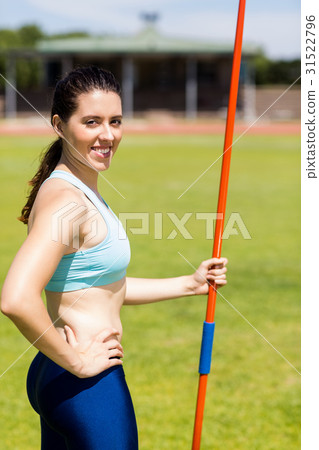Portrait of female athlete standing with javelin Portrait of female athlete standing with javelin 31522796