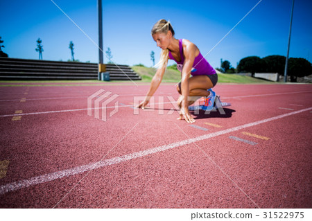 Female athlete ready to run on running track 31522975
