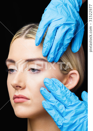 Woman has an examination of her skin before botox injection Woman has an examination of her skin before botox injection 31522977