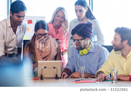 Group of coworkers using a tablet computer Group of coworkers using a tablet computer 31522981