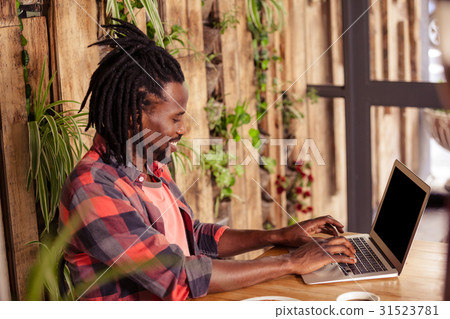 Profile of hipster man using laptop Profile of hipster man using laptop 31523781