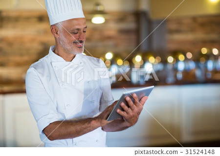 Smiling chef using digital tablet 31524148