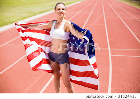 Happy female athlete holding up american flag 31524413