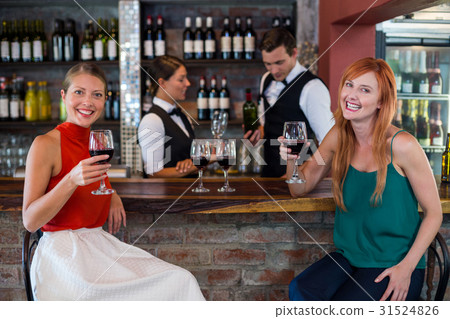 Portrait of happy woman holding a red wine glass at bar counter 31524826