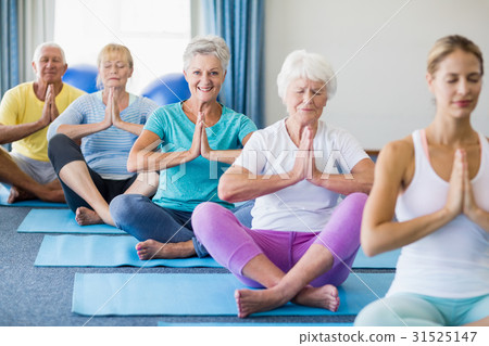 Instructor performing yoga with seniors Instructor performing yoga with seniors 31525147