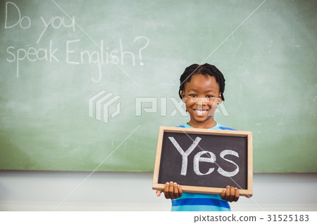 Schoolboy holding a slate in classroom which reads yes Schoolboy holding a slate in classroom which reads yes 31525183