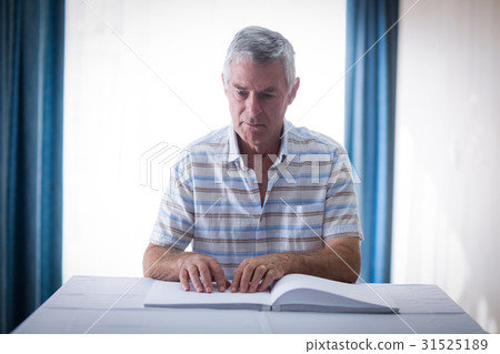 Blind man reading a braille book Blind man reading a braille book 31525189