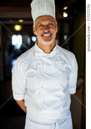 Portrait of chef standing with hands behind back Portrait of chef standing with hands behind back 31525556