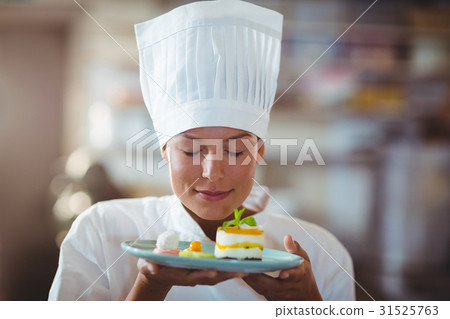 Female chef with eyes closed smelling food Female chef with eyes closed smelling food 31525763