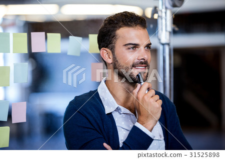 Businessman smiling and reflecting Businessman smiling and reflecting 31525898