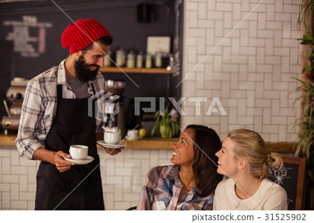 Waiter serving coffee and interacting with customers Waiter serving coffee and interacting with customers 31525902