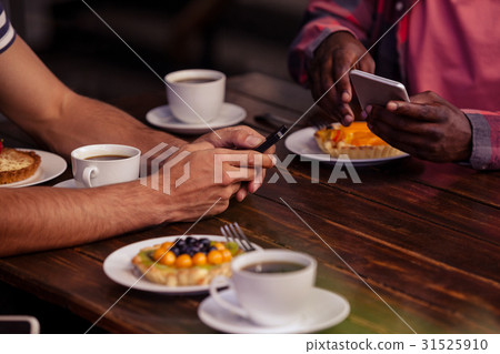Cropped image of friends eating pastries and drinking coffee 31525910