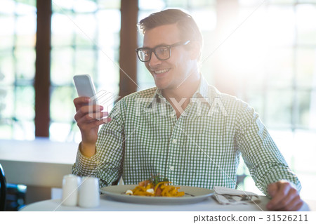 Man using mobile phone while having a lunch 31526211