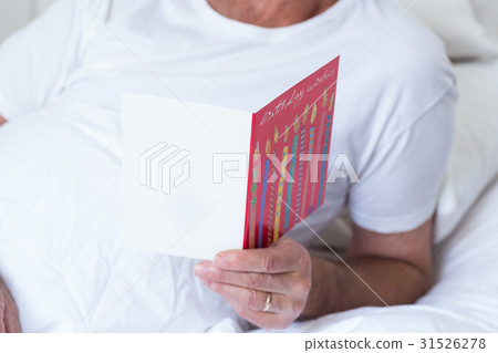 Senior man holding birthday greeting card 31526278