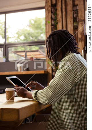 Man using digital tablet in cafeteria 31526314