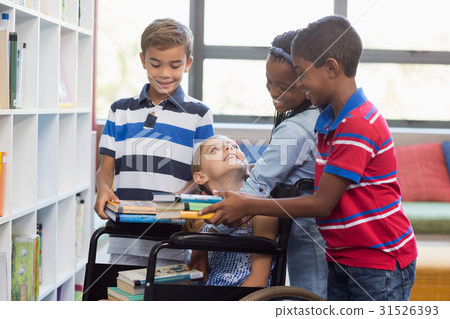 School kids giving books to disabled girl in library School kids giving books to disabled girl in library 31526393