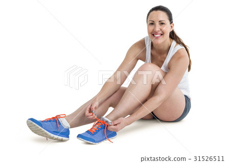 Portrait of athlete woman tying her running shoes 31526511