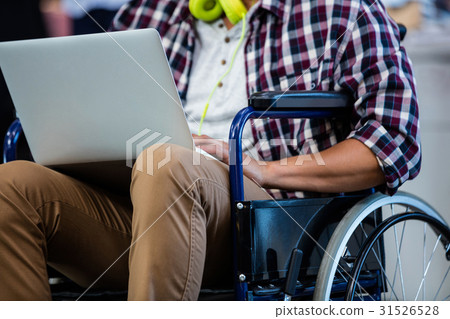 Designer in a wheelchair with a computer Designer in a wheelchair with a computer 31526528