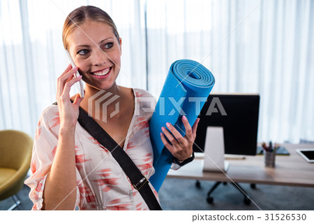 Casual business woman holding yoga mat Casual business woman holding yoga mat 31526530