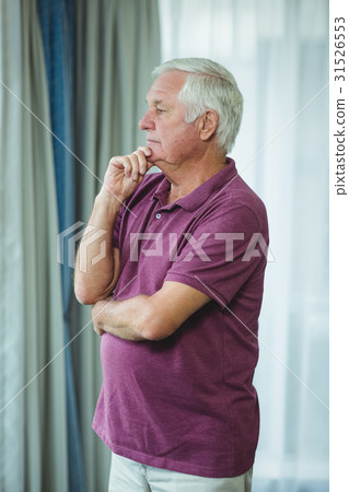 Portrait of senior man standing with hand on chin Portrait of senior man standing with hand on chin 31526553
