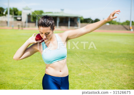Female athlete preparing to throw shot put ball Female athlete preparing to throw shot put ball 31526675