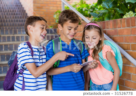 School kids looking at mobile phone School kids looking at mobile phone 31526778