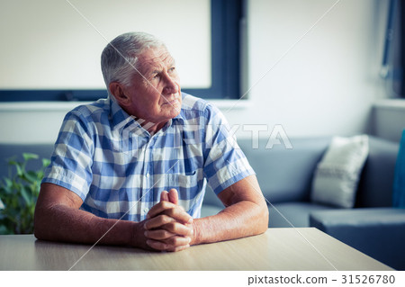 Worried senior man sitting in living room 31526780