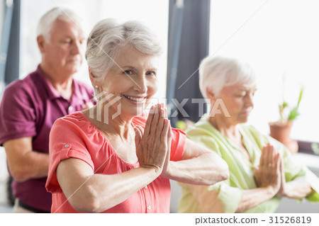 Seniors doing yoga with closed eyes 31526819