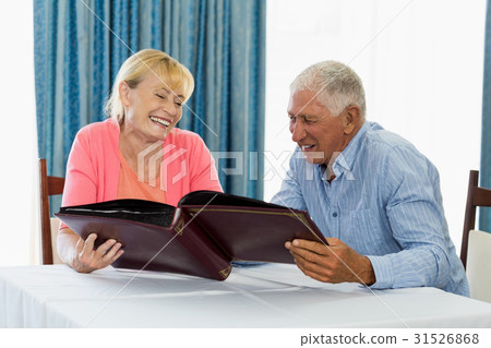 Senior couple looking at photo album Senior couple looking at photo album 31526868