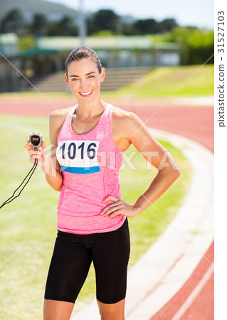 Portrait of female athlete showing stopwatch Portrait of female athlete showing stopwatch 31527103