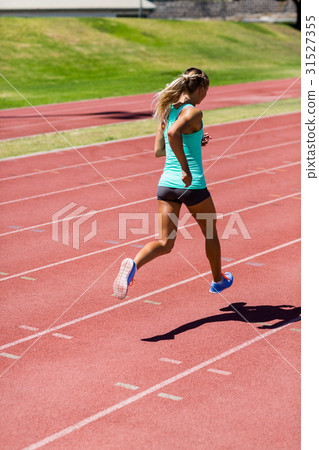 Female athlete running on the racing track Female athlete running on the racing track 31527355