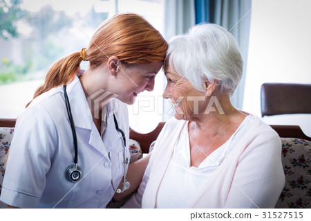 Smiling doctor and patient looking face to face Smiling doctor and patient looking face to face 31527515