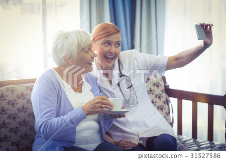 Smiling doctor and patient taking a selfie 31527586