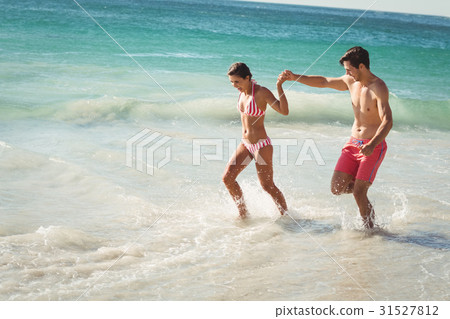 Couple running in water 31527812