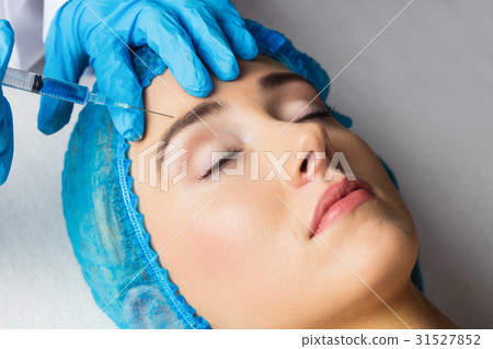 Woman receiving botox injection on her forehead 31527852