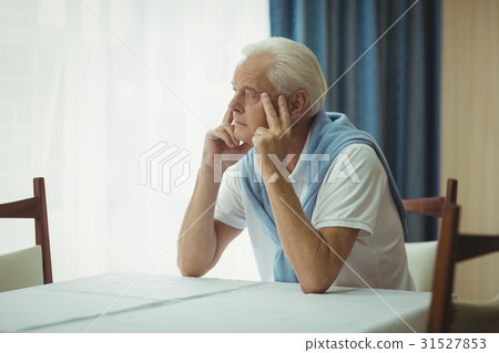Senior man sitting at a table 31527853