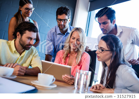 Group of coworkers watching a tablet computer Group of coworkers watching a tablet computer 31527915