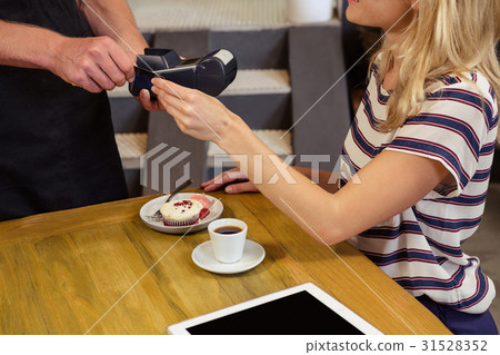 A cashier taking the money to his customer 31528352