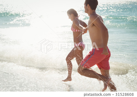 Couple running in water 31528608