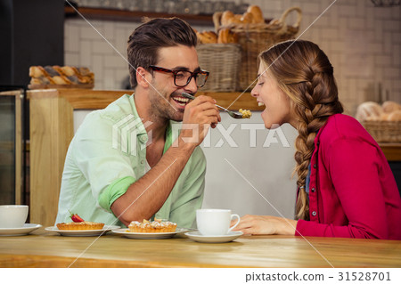 Smiling couple eating cake Smiling couple eating cake 31528701
