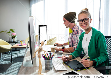 Casual colleagues using graphic tablet and computer Casual colleagues using graphic tablet and computer 31528703