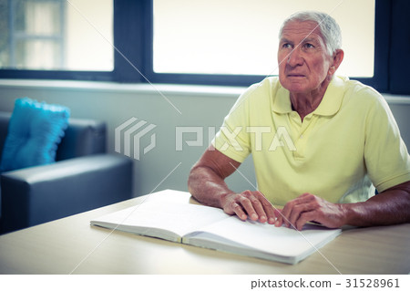 Senior blind man reading a braille book Senior blind man reading a braille book 31528961