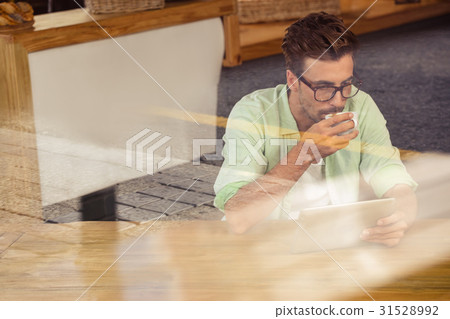Hipster using a tablet computer 31528992