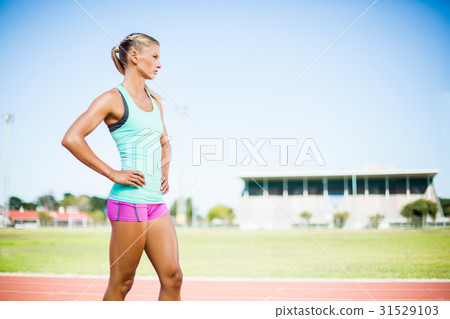 Female athlete standing with hand on hip Female athlete standing with hand on hip 31529103