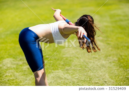 Female athlete carrying javelin on her shoulder 31529409