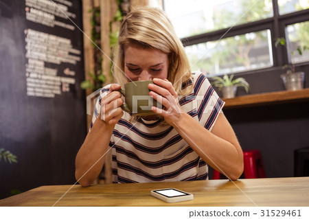 Woman drinking a hot beverage Woman drinking a hot beverage 31529461
