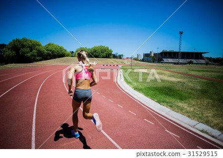 Rear view of female athlete running on the racing track Rear view of female athlete running on the racing track 31529515