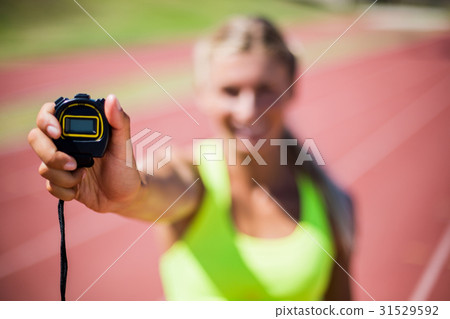 Female athlete showing stop watch 31529592