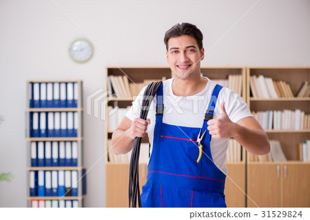 Young electrician with cable working in office 31529824